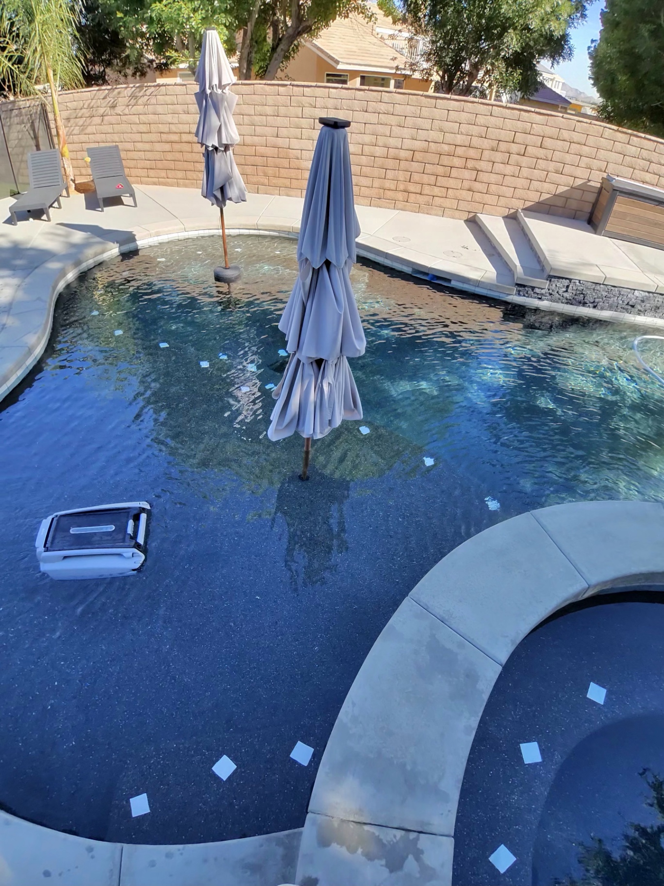 Robotic cleaner working a clear backyard pool in Hesperia